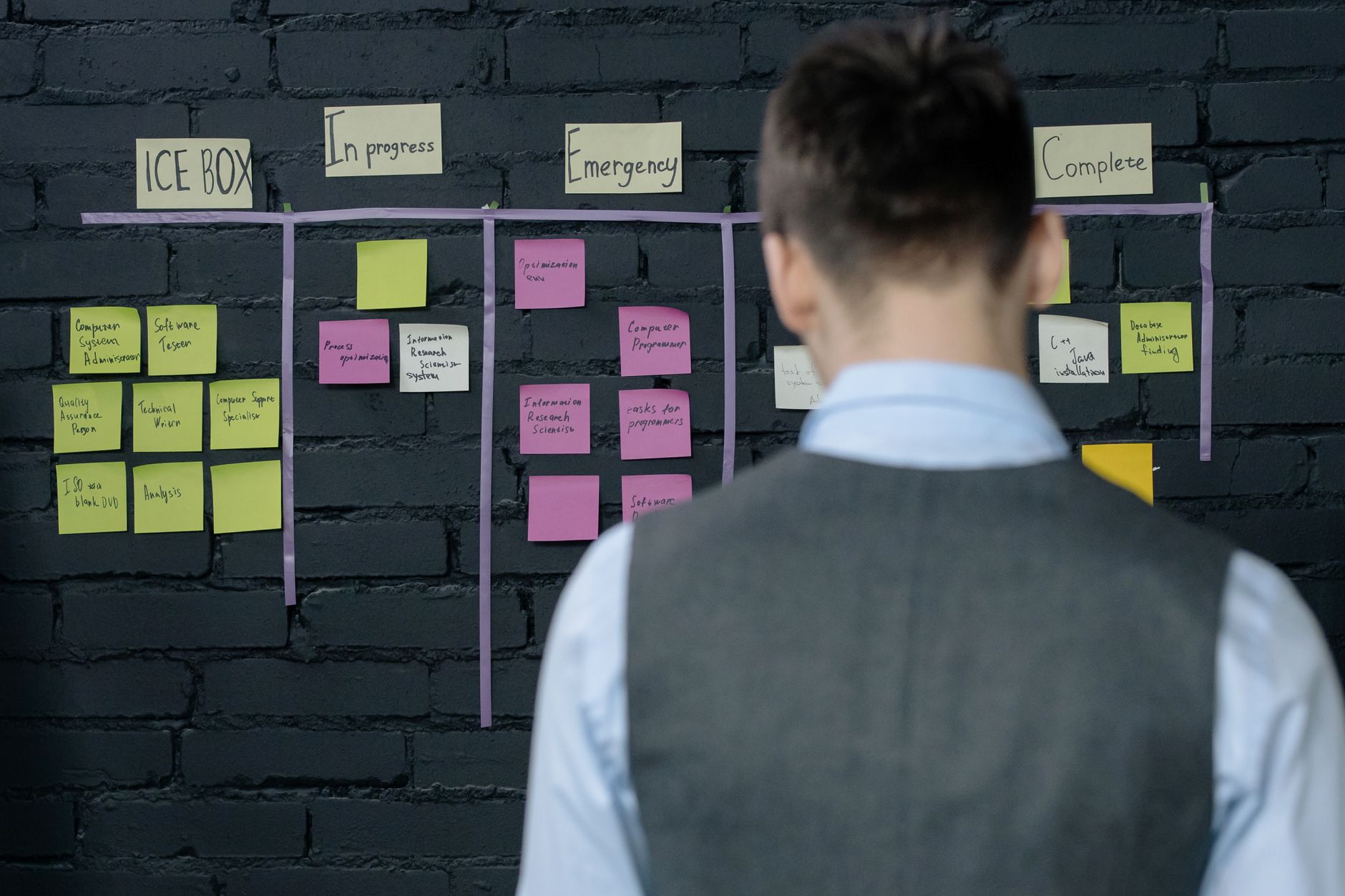 Équipe de production PME analysant un tableau de bord Lean lors d'un stand-up meeting quotidien